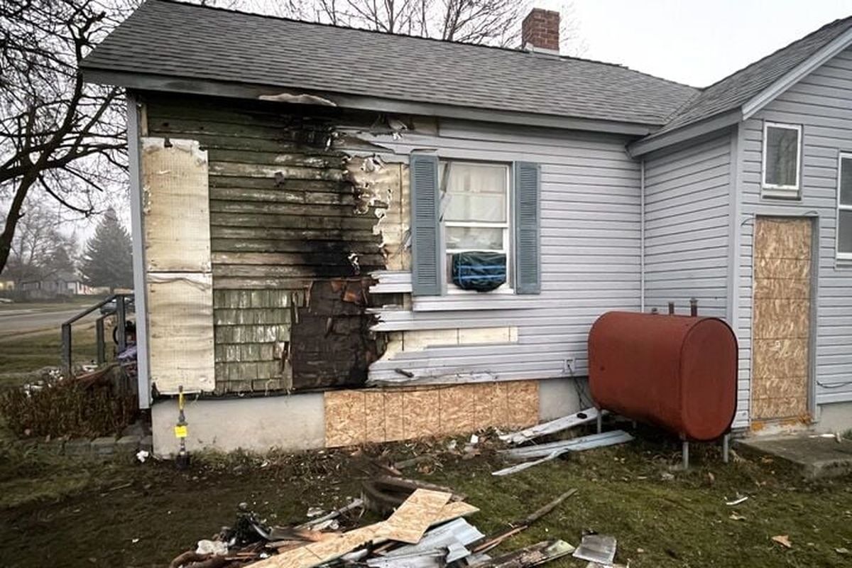 An alleged impaired driver crashed into Lynne Hubbard’s home Wednesday night on Courtland Avenue and Perry Street, sparking a fire on the side of the house. Hubbard was sleeping inside, but was uninjured as neighbors ran to her house, broke through the door and got her out. Another neighbor kept the driver at the scene and police arrested him.  (Garrett Cabeza / The Spokesman-Review)