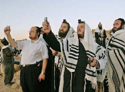 
Ultra-Orthodox Jews in prayer shawls use a mobile phone to take pictures.  
 (Associated Press / The Spokesman-Review)