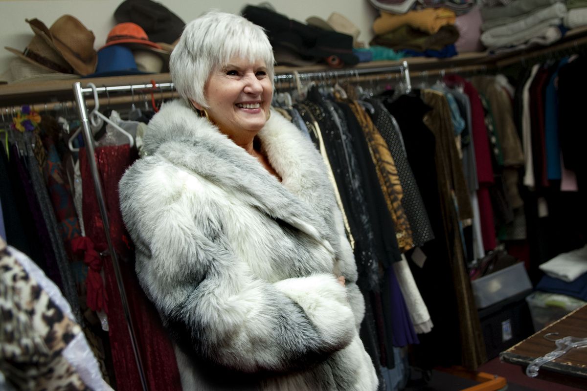 Jacki Badami, 74, of Post Falls, tries on a faux fur coat as she prepares for an upcoming fashion show to benefit area senior programs. (Kathy Plonka)