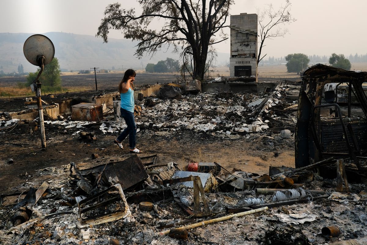 Karen Bunbury, a member of the Shuswap Tribe in Canada, reacts as she walks where the home she shared with her longtime partner Monty Piatope, a member of the Nez Perce Tribe, on Aug. 2 near Nespelem, Wash. The couple was living in a trailer next to Piatope’s childhood home as they worked to renovate it when the Chuweah Creek fire burned it down.  (Tyler Tjomsland/The Spokesman-Review)