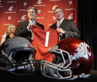 New Cougars football coach Mike Leach, left, and Washington State athletic director Bill Moos show what number they expect the team to become. (Christopher Anderson)