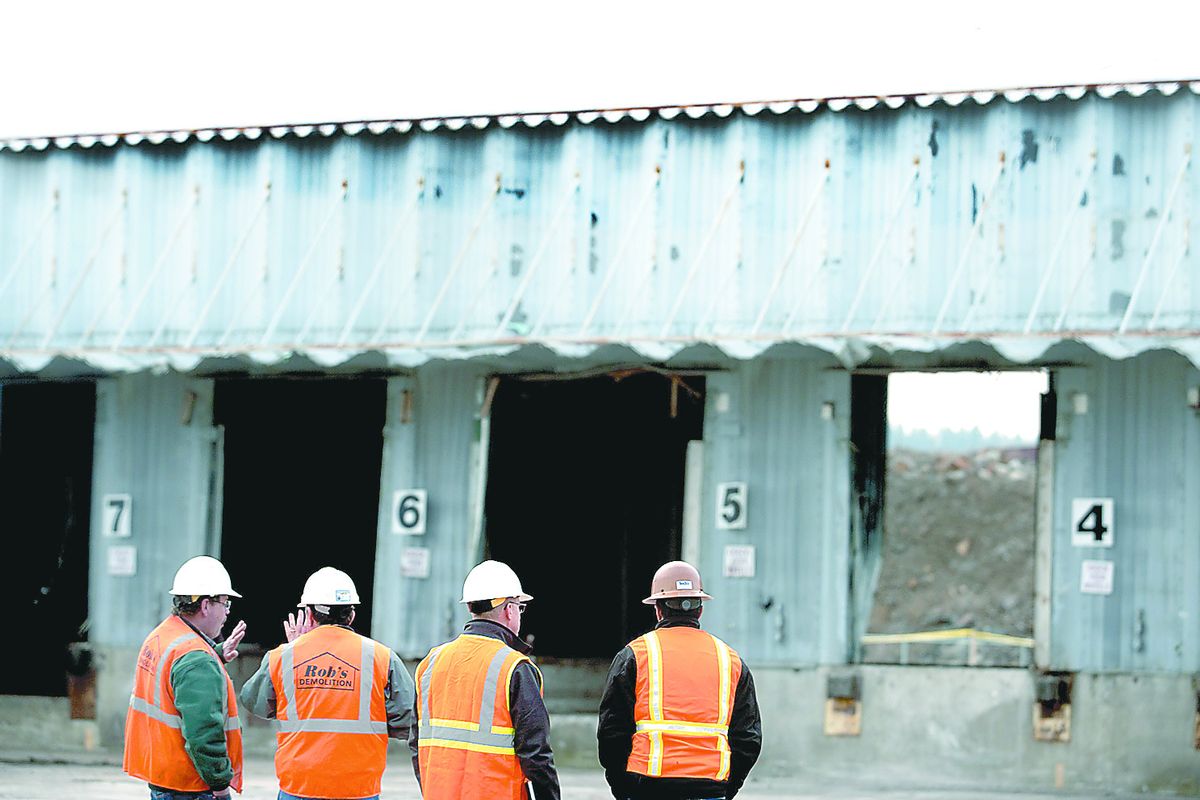 Construction workers discuss the demolition plan for the Pierone building March 2. A new WSU Spokane health clinic will be built at the site. (Kathy Plonka)