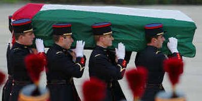 
Palestinian leader Yasser Arafat's coffin, draped with the Palestinian flag, is carried by a French military honor guard at Villacoublay air base southwest of Paris on Thursday. 
 (Associated Press photos / The Spokesman-Review)