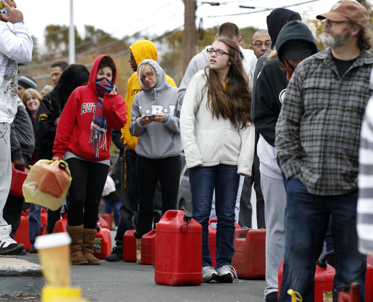 As temperatures begin to drop, people wait in line to fill containers with gas at a Shell gasoline filling station Thursday, Nov. 1, 2012, in Keyport, N.J. In parts of New York and New Jersey, drivers lined up Thursday for hours at gas stations that were struggling to stay supplied. The power outages and flooding caused by Superstorm Sandy have forced many gas stations to close and disrupted the flow of fuel from refineries to those stations that are open. (Mel Evans / Associated Press)