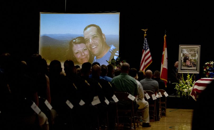 Sgt. Greg Moore and his wife Lindy are seen as part of a video during the funeral service for Sgt. Greg Moore at Lake City High School on Saturday, May 9, 2015. (Kathy Plonka / The Spokesman-Review)