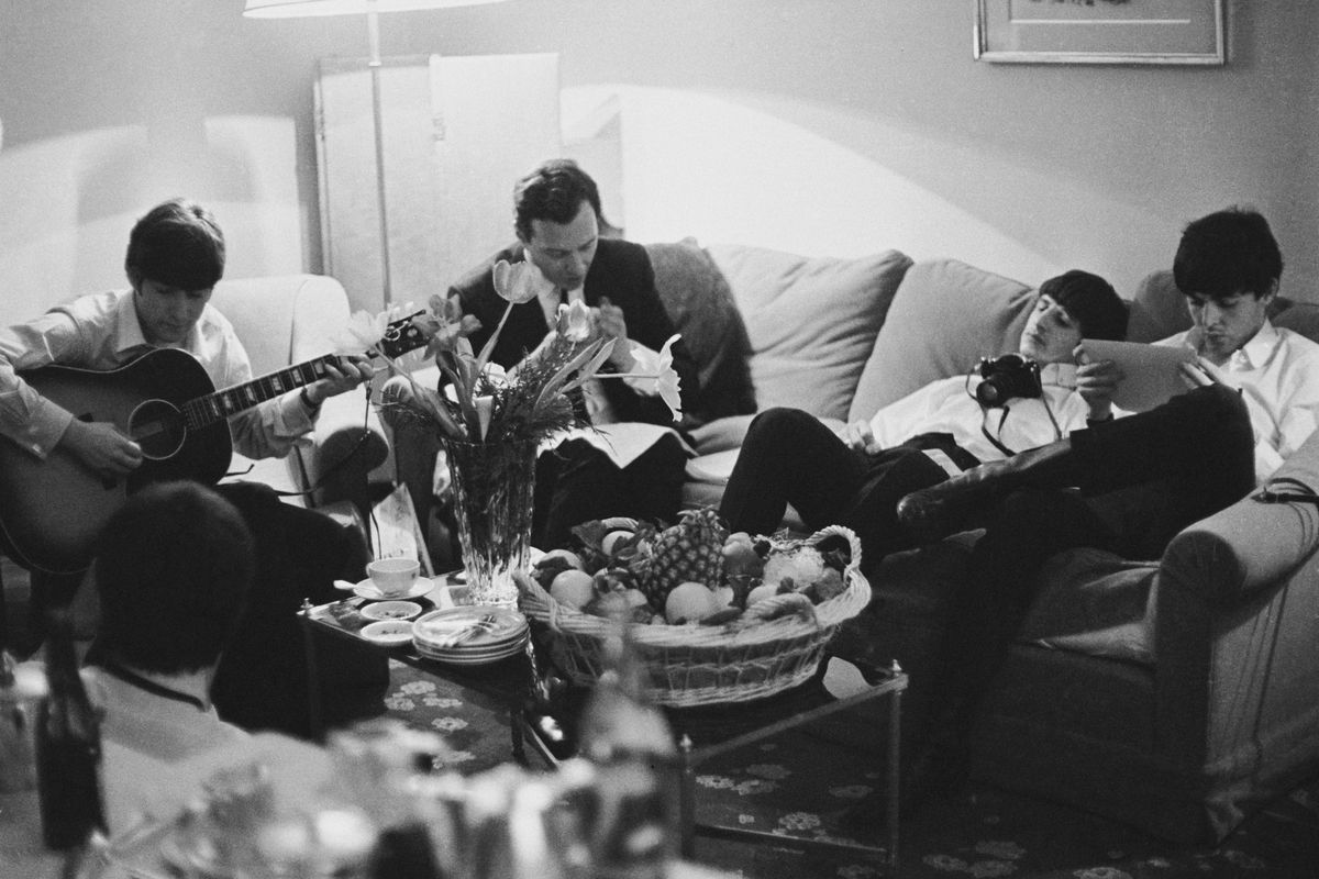 The Beatles relax in a hotel room in Paris, on Jan. 16, 1964. From left to right are John Lennon, band manager Brian Epstein, Ringo Starr and Paul McCartney.  (Harry Benson/Getty Images North America/TNS)