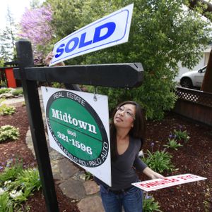 FILE - In this April 5, 2010 photo, Joann Weber, of Midtown Realty, changes the sign from "Sale Pending" to "Sold" at a home that just sold in Palo Alto, Calif. Real estate agents are working seven days a week. Homebuilders are staying open until 10 p.m. All of this frenzy is to make sure first-time homeowners can qualify for an $8,000 tax credit for first-time home buyers that expires Friday, April 30. (Paul Sakuma / Associated Press)