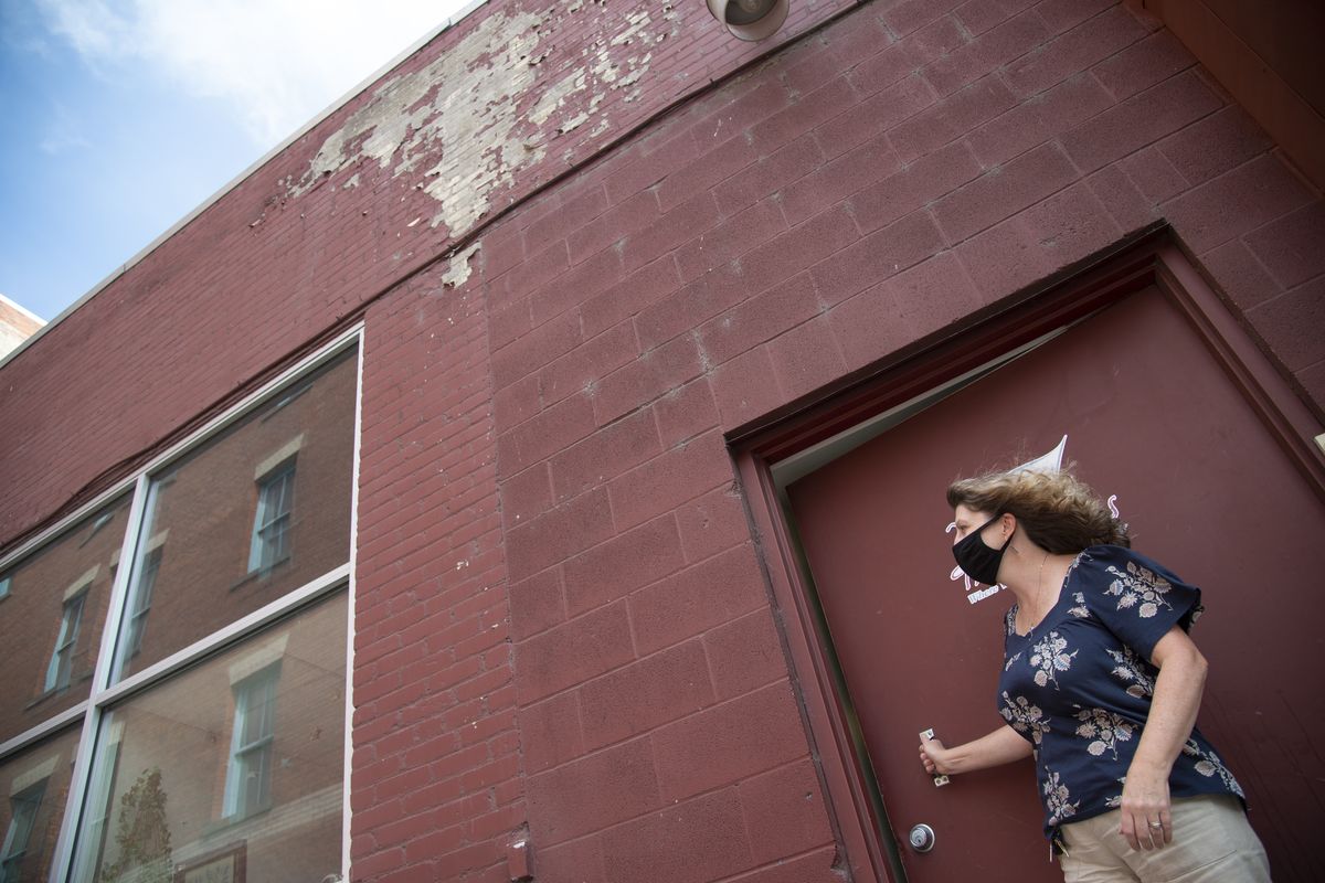 Women’s Hearth director Susan Tyler-Babkirk stands in the alleyway behind the downtown women’s drop-in center where a grant and volunteer labor from the Rotary Club will repaint the building that’s been peeling because of a leaky roof, which has been replaced. Photographed Monday, Aug. 24, 2020 at the center on 2nd Avenue in downtown Spokane.  (Jesse Tinsley/The Spokesman-Review)