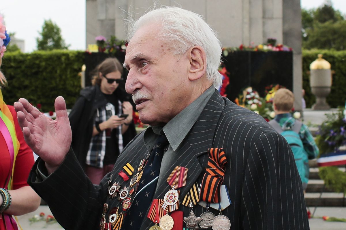 Soviet war veteran David Dushman center, speaks to people holding Ukrainian flags as he attends a wreath laying ceremony May 8, 2015 at the Russian War Memorial in the Tiergarten district of Berlin. (Markus Schreiber)