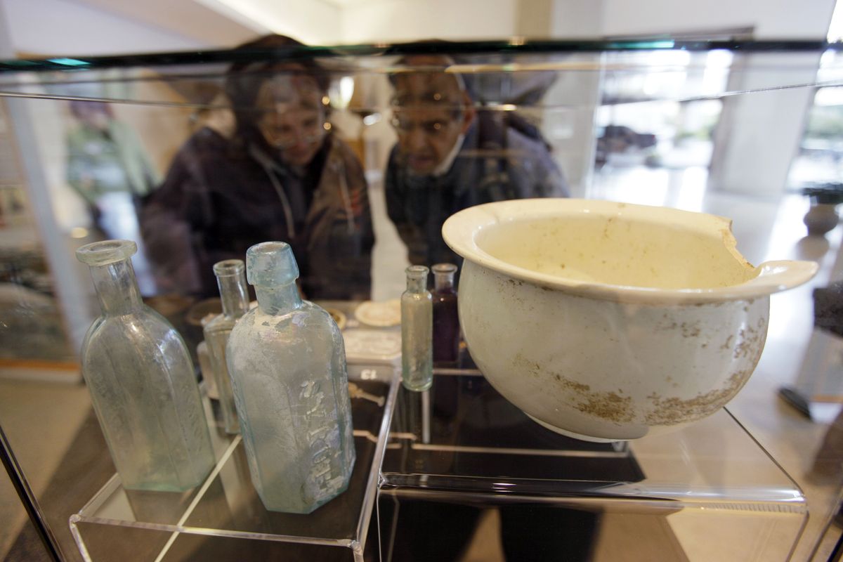 A couple look over medicine bottles and a chamber pot found in a privy. The items are part of an exhibit in San Francisco of artifacts recently dug up from the Transbay Terminal construction site. (Associated Press)