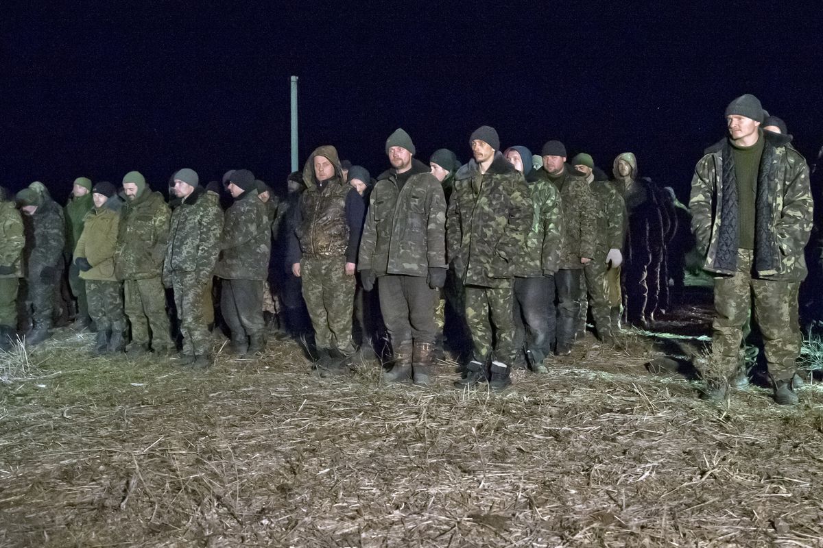 Ukrainian prisoners wait in formation before a prisoner exchange Saturday in Russia-backed, separatist-controlled territory near Zholobok, Ukraine. Fifty-two rebels and 139 Ukrainian soldiers reportedly were exchanged. (Associated Press)