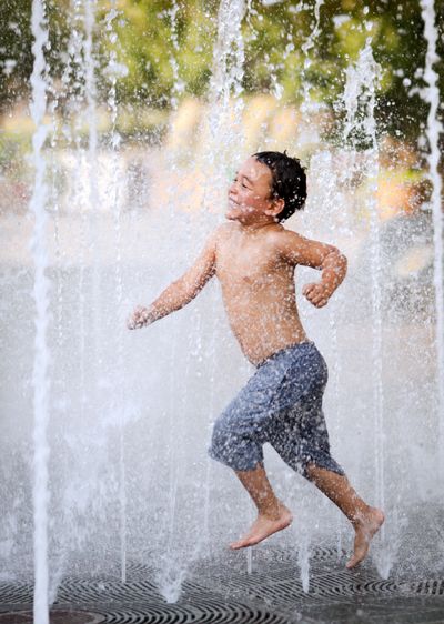 Playing it cool: With temperatures in the low 90s, Jordan Larson, 4, cools off in the Rotary Fountain in Riverfront Park on Monday afternoon. Temperatures will drop steadily throughout the week, with a high near 77 expected by Thursday. By Sunday, the high is expected to reach 70, according to the National Weather Service. (Colin Mulvany)