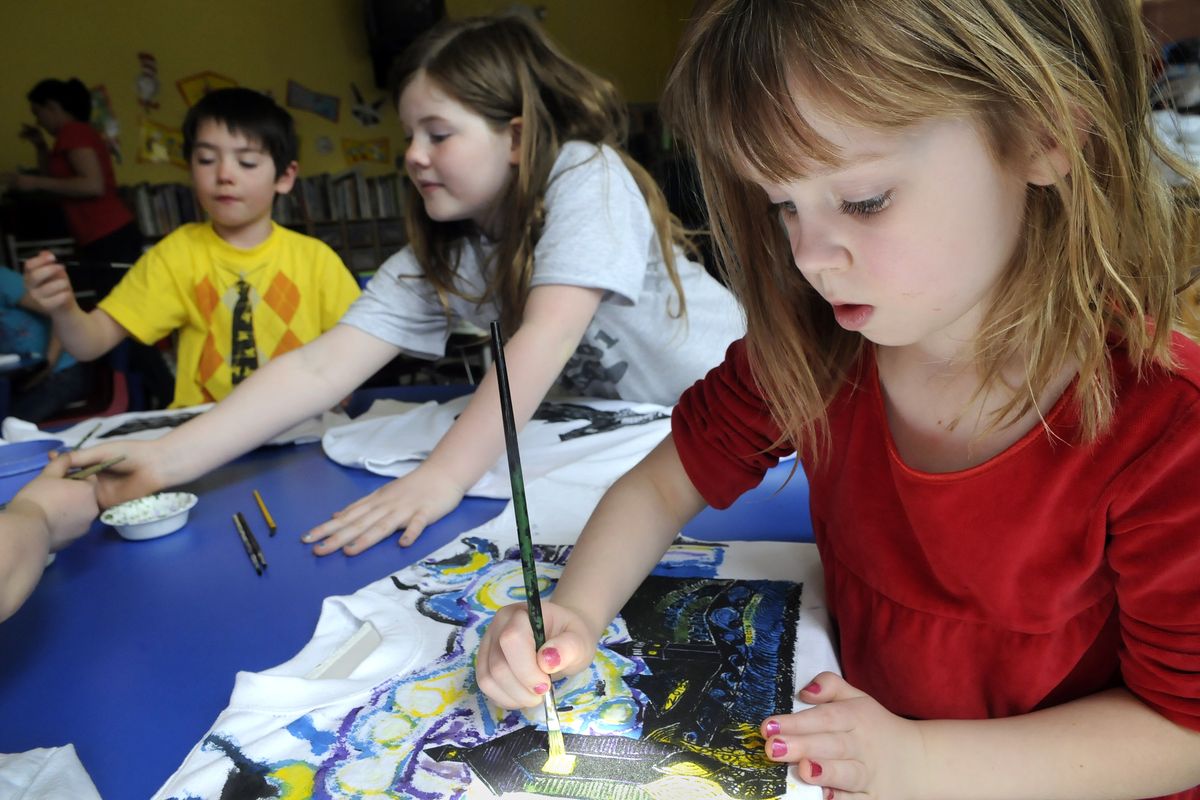 Orchard Prairie kindergartner Katie Gelhausen, right, second-grader Isabelle Borders, center, and first-grader, Jasper Marsh, left, work on “Starry Night” T-shirts April 11 at the school. Art teacher Kirsten Schierman won a $200 grant and is using the funds to create the glow-in-the-dark shirts, combining the study of stars and impressionist art. (Dan Pelle)