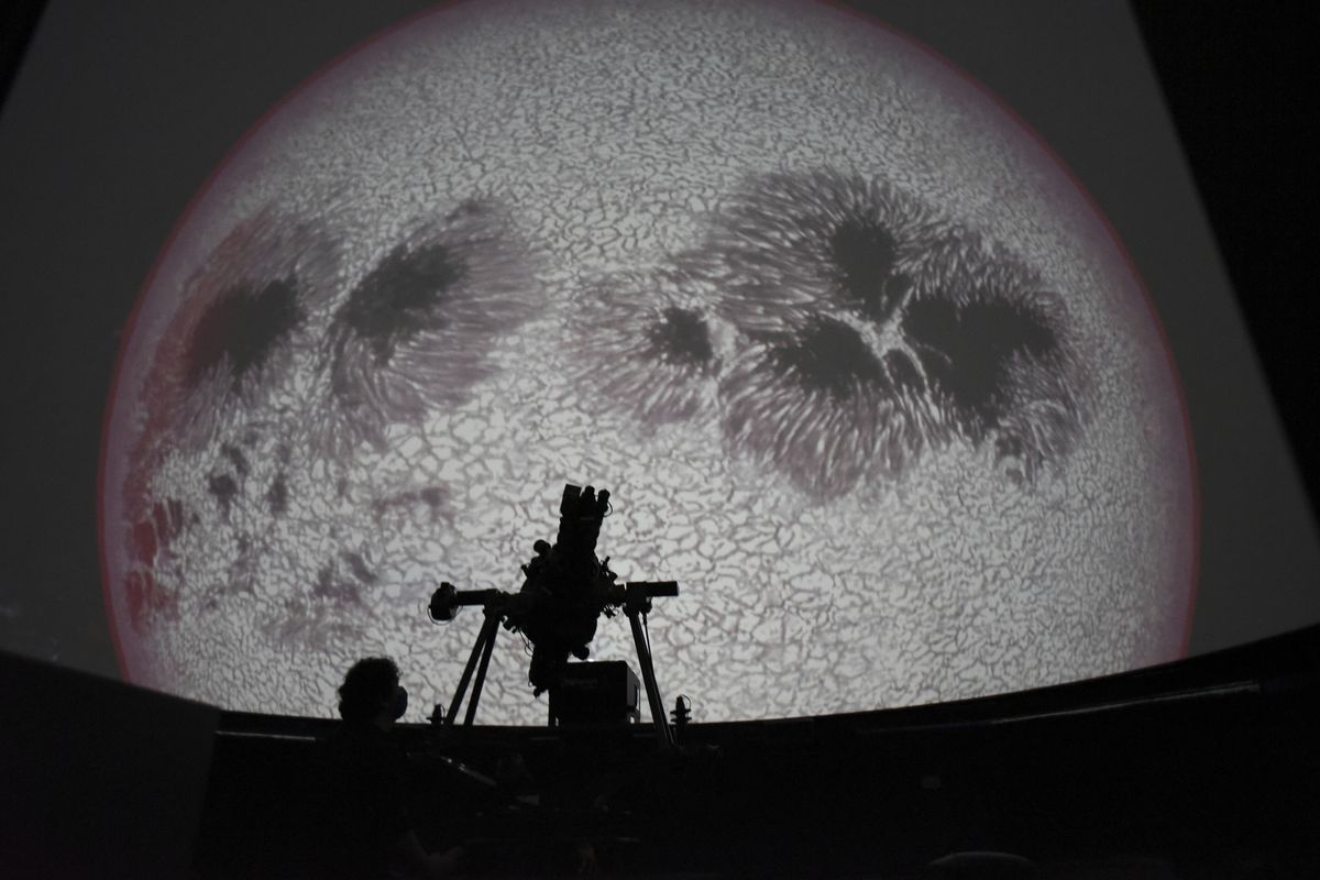 Researcher Ivannia Calvo, silhouetted against a solar satellite image, works inside the Solar Astronomical Observatory in San Jose, Costa Rica, Friday, April 30, 2021. Costa Rica approved a law creating a space agency on Feb. 18.  (Carlos Gonzalez)