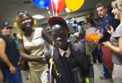 
Eliow walks with his mother, Akout Agang,  through a crowd of well-wishers at Spokane International Airport after being reunited with his family Thursday night. Civil war, poverty and government bureaucracy separated the Sudanese boy  from his family. 
 (Photos by Holly Pickett / The Spokesman-Review)