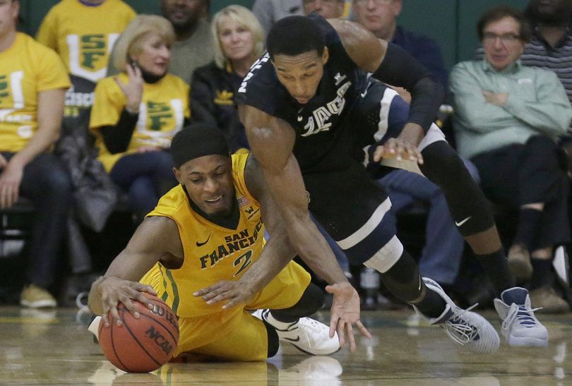 San Francisco forward Uche Ofoegbu, left, reaches for a loose ball under Gonzaga guard Eric McClellan during the first half of an NCAA college basketball game in San Francisco. (Jeff Chiu / Associated Press)