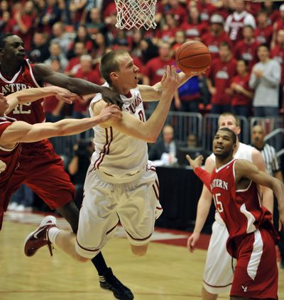 WSU's Charlie Enquist powers through the EWU defense, including a foul by Cliff Ederaine (42) in the first half, Dec. 3, 2011 in Pullman, Wash. (Dan Pelle / The Spokesman-Review)