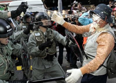 
Hong Kong police shoot pepper spray at a protester Saturday near the Hong Kong Convention and Exhibition. World Trade Organization delegates meeting at the center are negotiating an accord on farming, manufacturing and services. 
 (Associated Press / The Spokesman-Review)