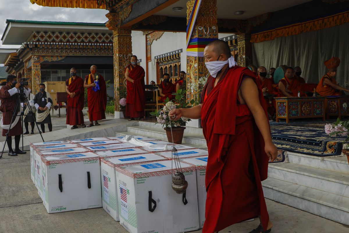 Monks from Paro’s monastic body perform a ritual as 500,000 doses of Moderna COVID-19 vaccine gifted from the United States arrived July 17 at Paro International Airport in Bhutan.  (HONS)