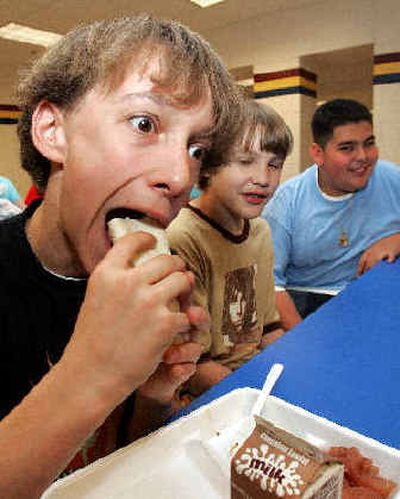 
Marietta Middle School eighth-grader Garin Hughes eats his lunch as two friends look on at the school cafeteria in Marietta, Ga., earlier this month. 
 (Associated Press / The Spokesman-Review)