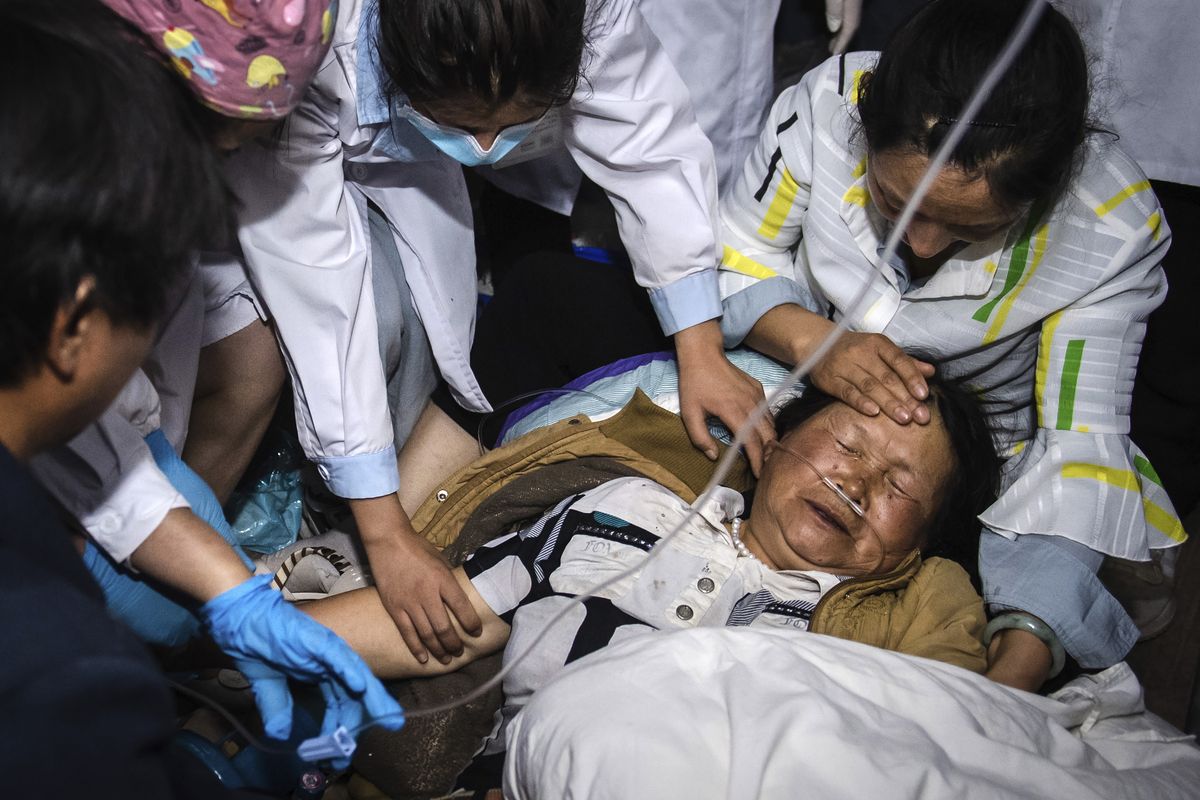 Medical workers treat a woman after an earthquake in Yangbi Yi Autonomous County in southwestern China’s Yunnan Province, early Saturday.  (Hu Chao)