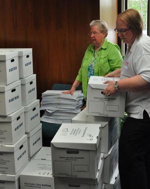 OLYMPIA -- Employees at the Washington Secretary of State's office handle boxes of petitions submitted by the sponsors of I-1183, which would privatize liquor sales. (Jim Camden)
