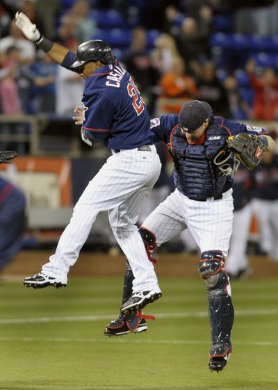 Alexi Casilla, left, delivered in the ninth. (Associated Press / The Spokesman-Review)