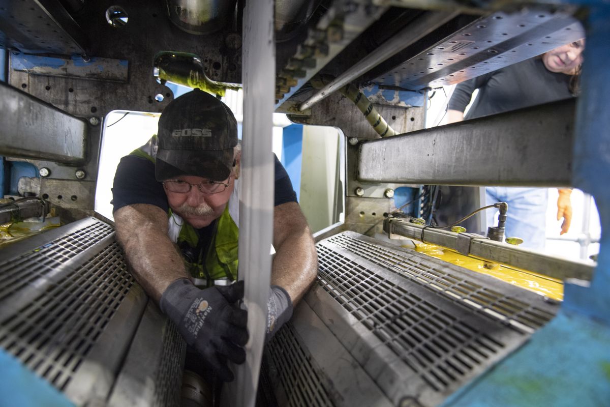 Thomas Rylands, right, a press expert from imPRESSions Worldside, manually guides the paper web through the Goss SSC Magnum press at Northwest Offset Printing in Spokane Valley, on June 29. The press printed The Spokesman-Review for the first time that night.  (JESSE TINSLEY/THE SPOKESMAN-REVIEW)