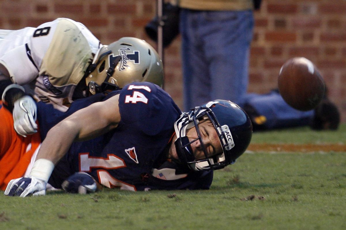 Idaho’s Gary Walker, left, defends as Virginia’s Matt Snyder hits the turf after diving for a pass. (Associated Press)