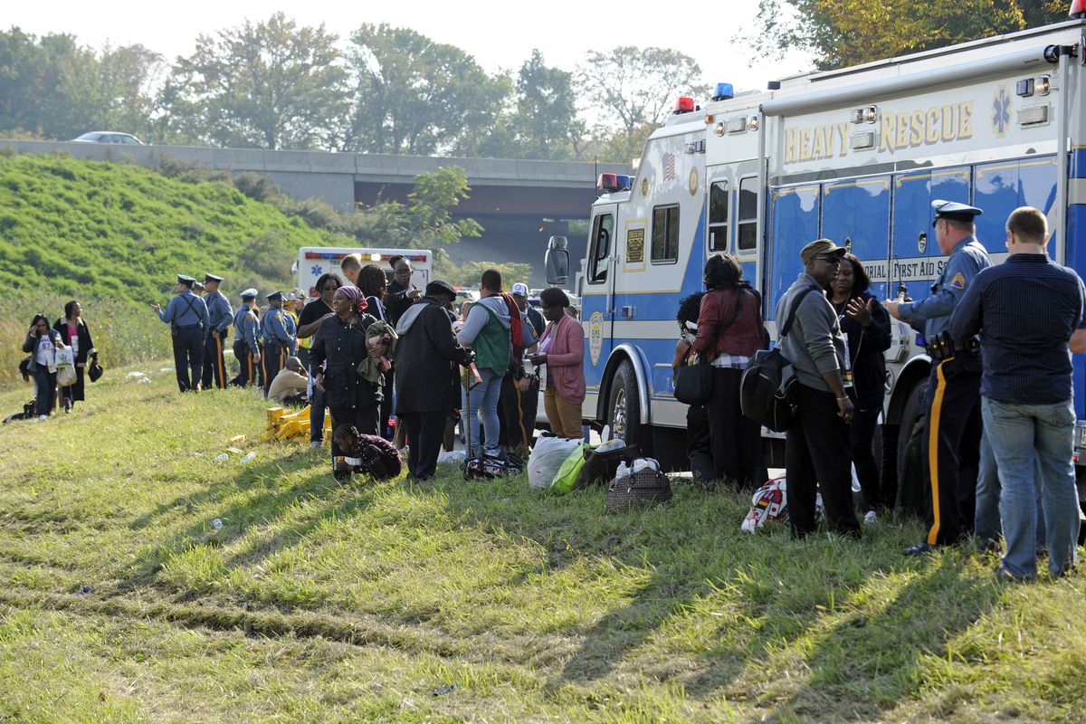 Passengers wait after their bus overturned in a ditch at an exit ramp off Route 80 in Wayne, N.J. Saturday, Oct. 6, 2012. The chartered tour bus from Toronto carrying about 60 people overturned on an interstate exit ramp. Three people have been taken to hospital with non-life-threatening injuries. (Bill Kostroun / Fr51951 Ap)