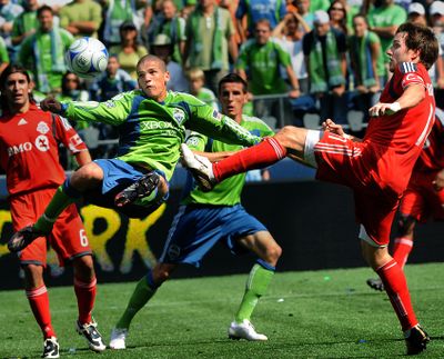 Seattle’s Osvaldo Alonso, center, takes a shot on goal against Toronto FC. (Associated Press / The Spokesman-Review)