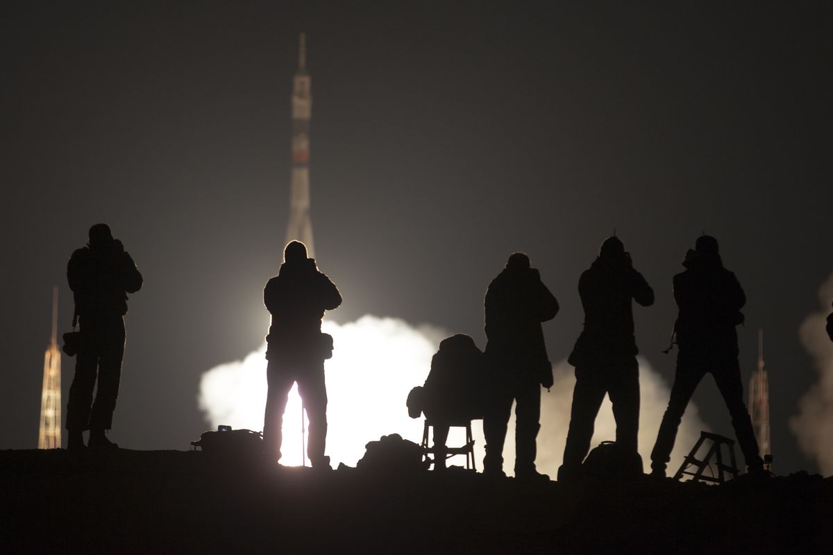 Journalists take photos as the rocket carrying a new crew to the International Space Station blasts off from the Baikonur cosmodrome in Kazakhstan early today. (Associated Press)