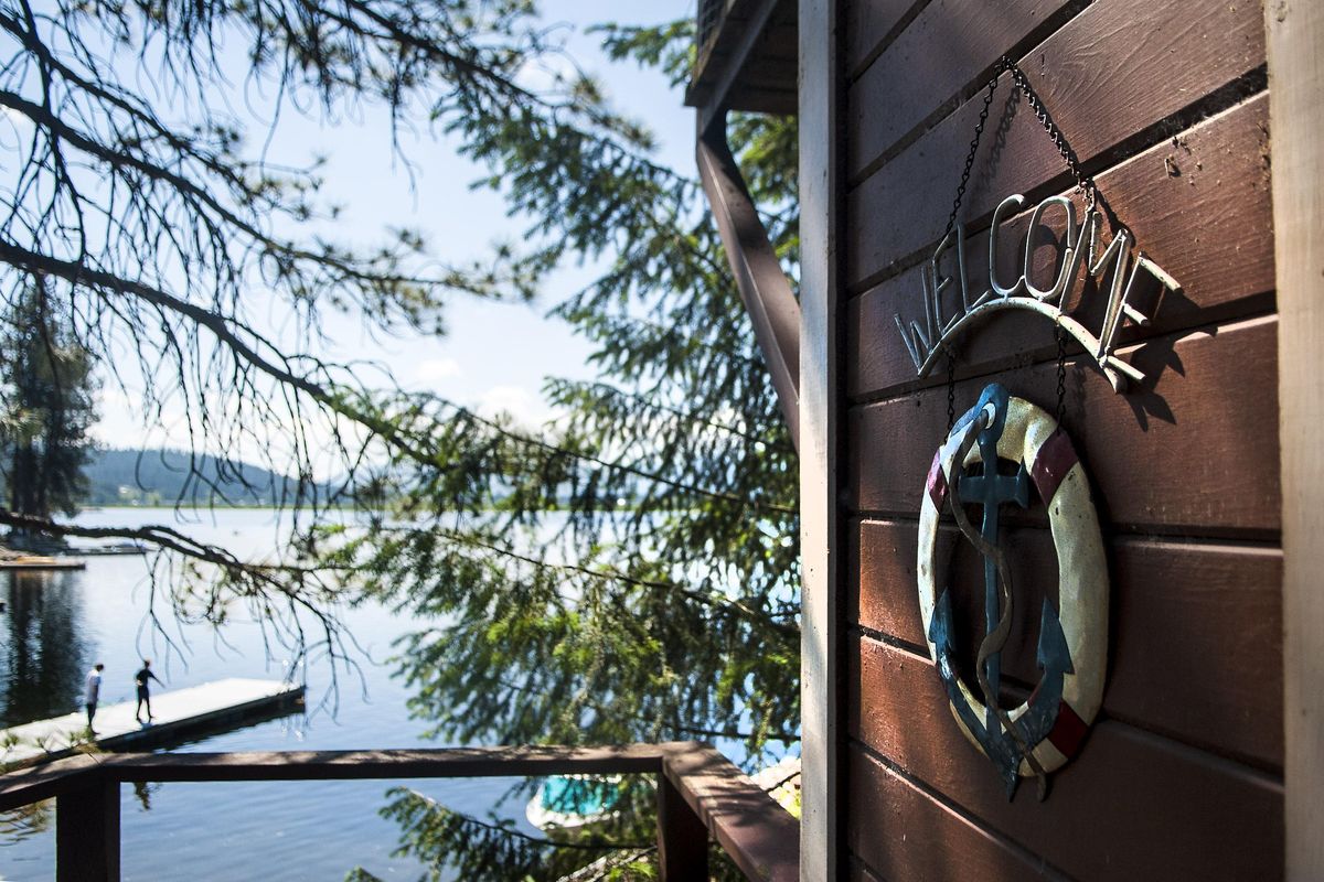 Brothers Zach and Drew Ewing fish from their families dock on Newman Lake recently. The cabins have been owned by their family for generations. (Kathy Plonka / The Spokesman-Review)