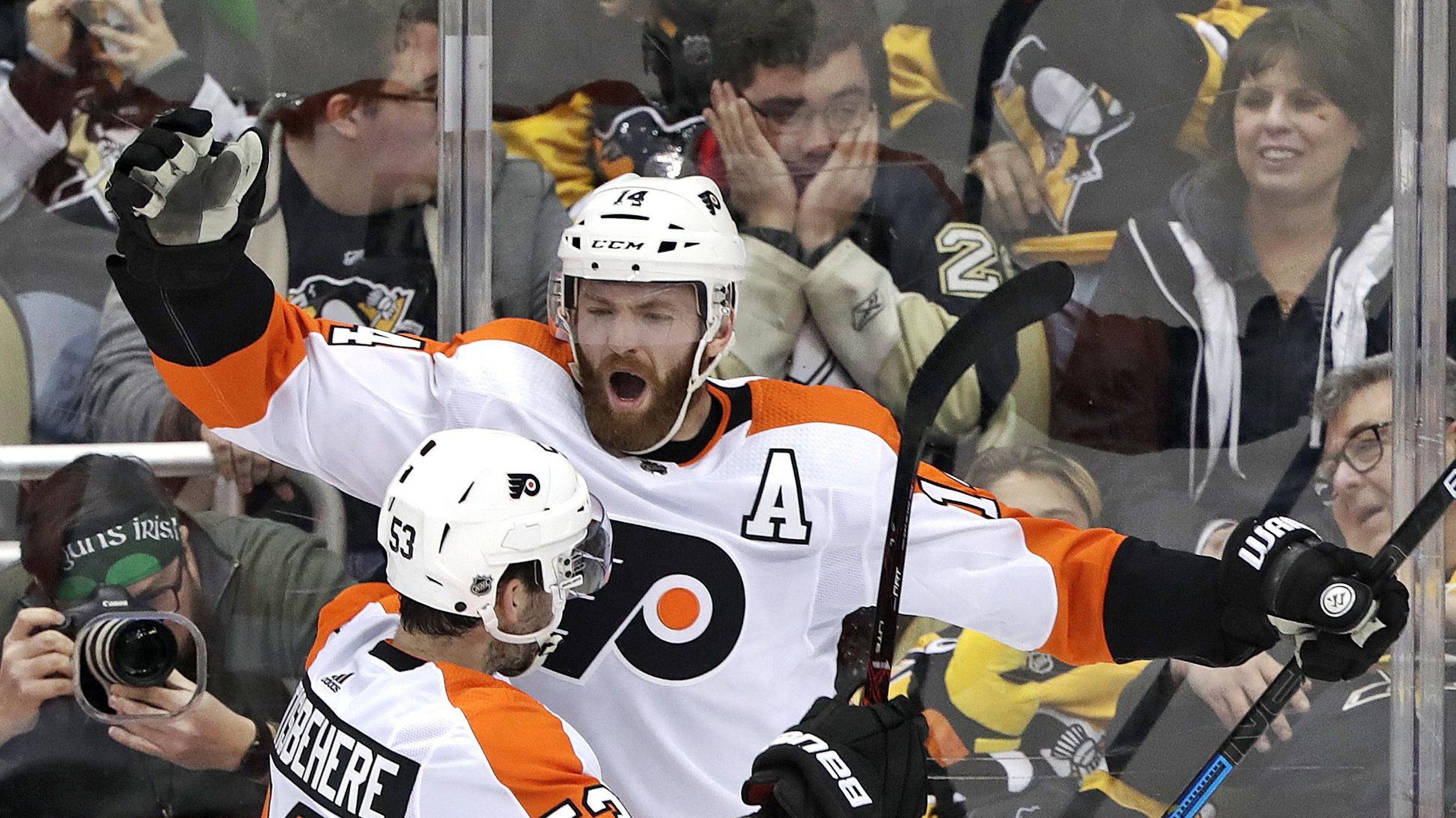 Philadelphia Flyers' Sean Couturier (14) celebrates with Shayne  Gostisbehere (53) after getting the game-winning goal past Pittsburgh  Penguins goaltender Matt Murray with 3.4 seconds left in the overtime  period of an NHL