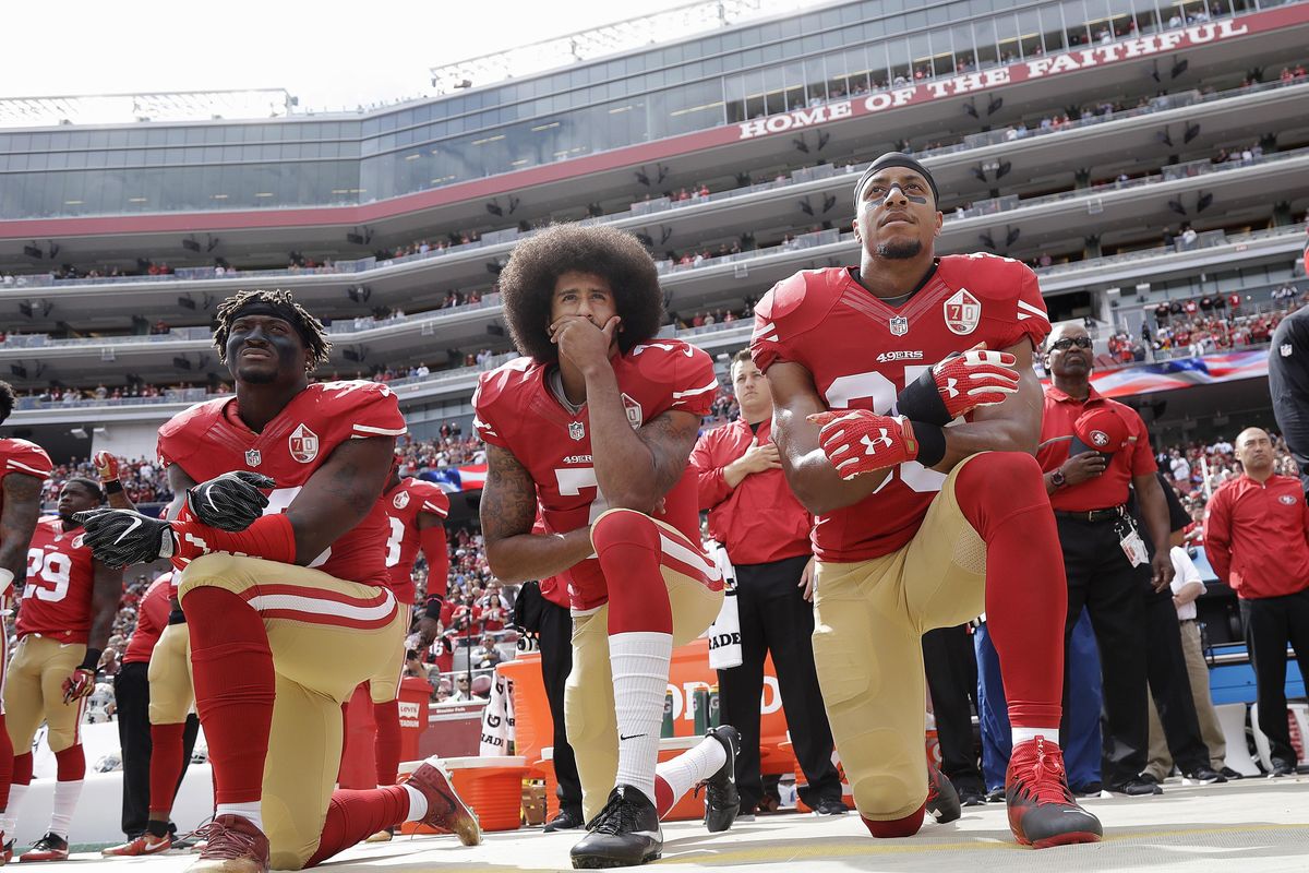 In this Oct. 2, 2016 file photo, from left, San Francisco 49ers outside linebacker Eli Harold, quarterback Colin Kaepernick and safety Eric Reid kneel during the national anthem before an NFL football game against the Dallas Cowboys in Santa Clara, Calif. An arbitrator is sending Kaepernick’s grievance with the NFL to trial, denying the league’s request to throw out the quarterback’s claims that owners conspired to keep him out of the league because of his protests of social injustice. (Marcio Jose Sanchez / Associated Press)