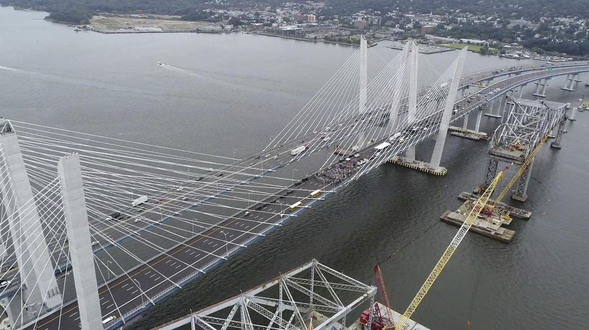 In this Sept. 7, 2018,  image made from video provided by the New York Governor’s Office, state officials and workers gather to celebrate the official opening of the second span, right, of the Gov. Mario M. Cuomo Bridge in Nyack, N.Y. The New York State Department of Transportation said Thursday, Aug. 15, 2019, that roughly year-old signs for the suburban bridge named after the former governor are being patched over because his middle initial is missing. (Kevin Coughlin / Associated Press)
