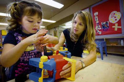 
Marli Jerald lends a helping hand to her daughter Emily as they work to remove a wheel from a toy truck Dec. 5, in Ginger Case's Davis Elementary preschool class in College Place, Wash. Associated Press
 (Associated Press / The Spokesman-Review)