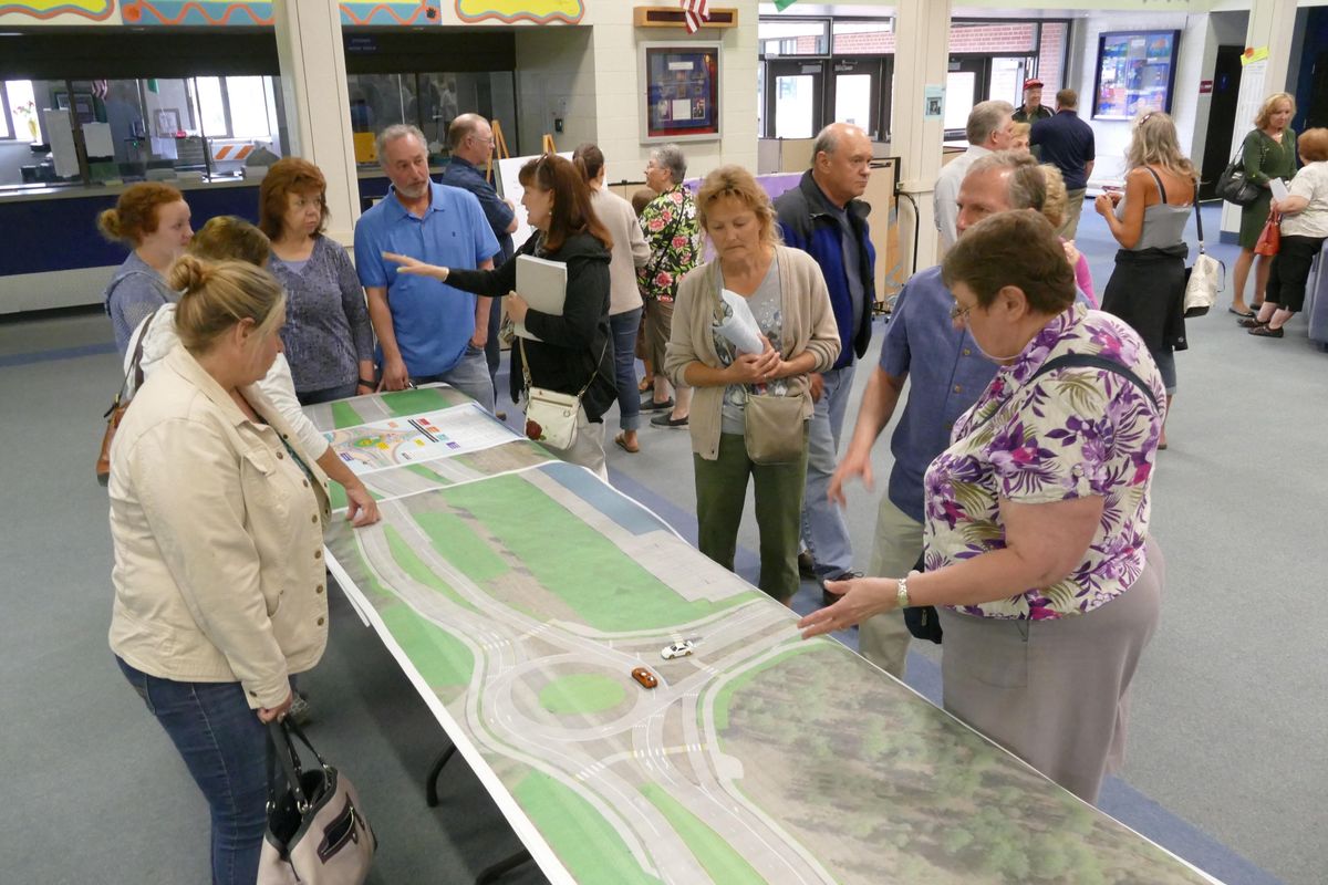 Neighbors pore over maps that show a proposed roundabout on Highway 2 to allow access to the new Costco store proposed in the Mead area Wednesday, May 31, 2017. There was a public meeting at Northwood Middle School Wednesday where representatives of Costco and Washington Department of Transportation answered questions about the project. (Jesse Tinsley / The Spokesman-Review)
