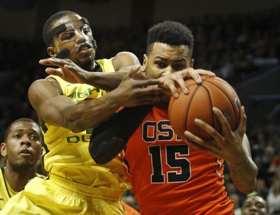 Oregon's Johnathan Loyd battles Oregon State's Eric Moreland for a rebound during the second half on Sunday. (Associated Press)