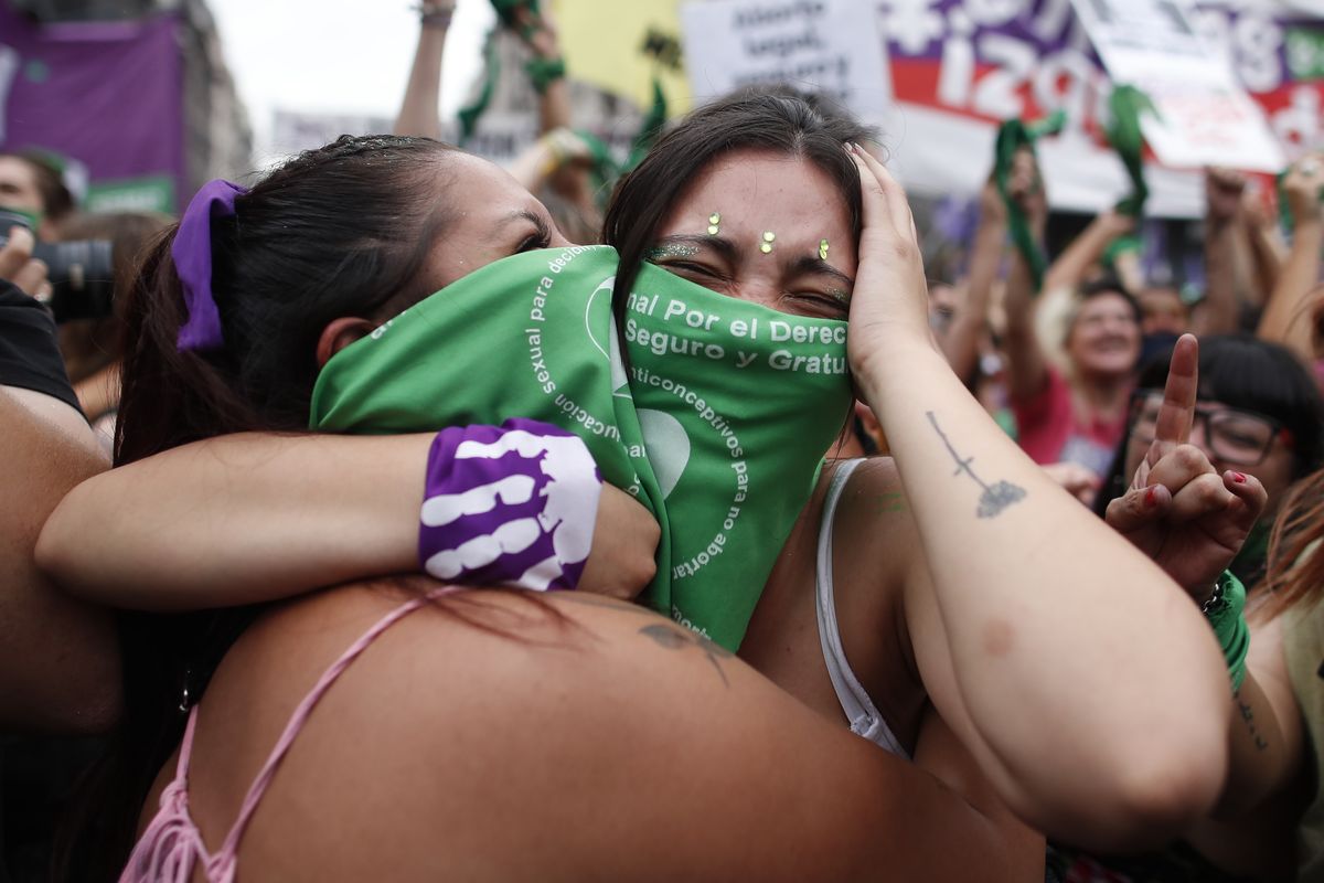 Abortion-rights activists celebrate as Argentine lower house approves a bill that would legalize abortion outside Congress in Buenos Aires, Argentina, Friday, Dec. 11, 2020. The bill now moves to the Senate.  (Natacha Pisarenko)