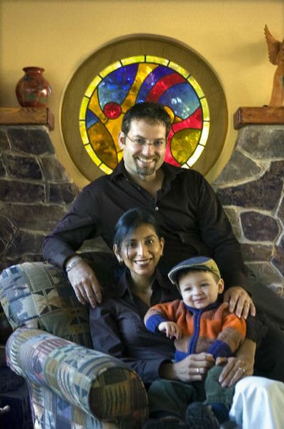 
Aaron and Gabriela Ausland sit with their son, Thiago, at The Hearth, a guesthouse in North Spokane that serves the Krista Foundation, started by Aaron and the parents of his former wife, Krista, who was killed in a bus accident in Bolivia. 
 (Photo by Christopher Anderson / The Spokesman-Review)