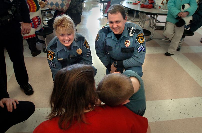 Sergeants Christie Wood and Bill Tilson of the Coeur d'Alene Police Department try to make friends with a leery young boy at the annual foster family Christmas party Saturday, Dec. 17, 2005 at Post Falls High School.  Officers brought donations of stuffed animals and blankets, but spent time circulating among the children, many of whom have had negative experiences with police officers when they were removed from their birth families.   About 280 foster children in North Idaho attended a party and received gifts at the party organized by staff from Idaho Health and Welfare.   Jesse Tinsley/The Spokesman-Review (Jesse Tinsley / The Idaho Spokesman Review)