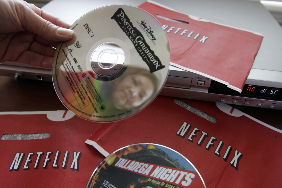Netflix customer Carleen Ho holds up DVD movies, “Talladega Nights” and “Pirates of the Caribbean,” that she rented from Netflix. The company is a current favorite of short sellers, who believe the stock will falter because of what they consider an inflated price and too much competition. (File Associated Press)