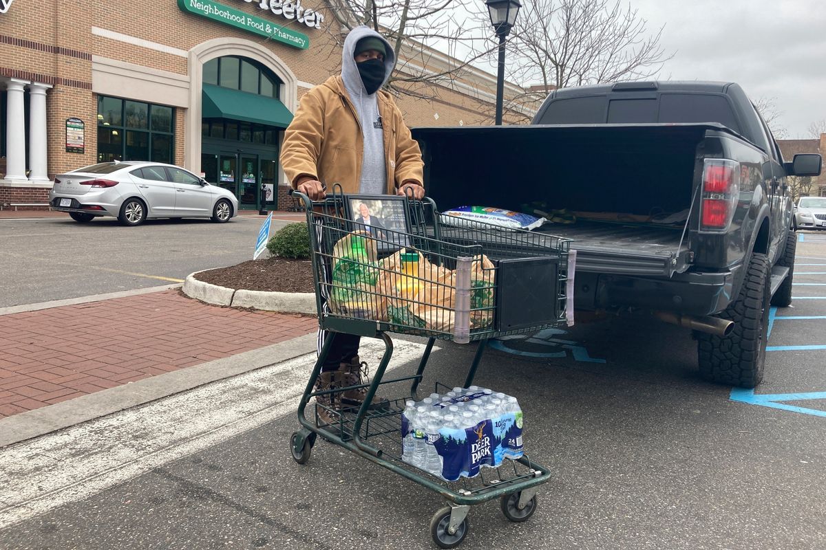 Chris Stokes picks up extra provisions at a grocery store in Norfolk, Va., on Friday Jan. 21, 2022, as the city prepares for an upcoming snowstorm.  (Ben Finley)