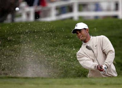 
Tiger Woods made this shot out of the bunker on the 11th hole of the South Course at Torrey Pines on Saturday.
 (Associated Press / The Spokesman-Review)