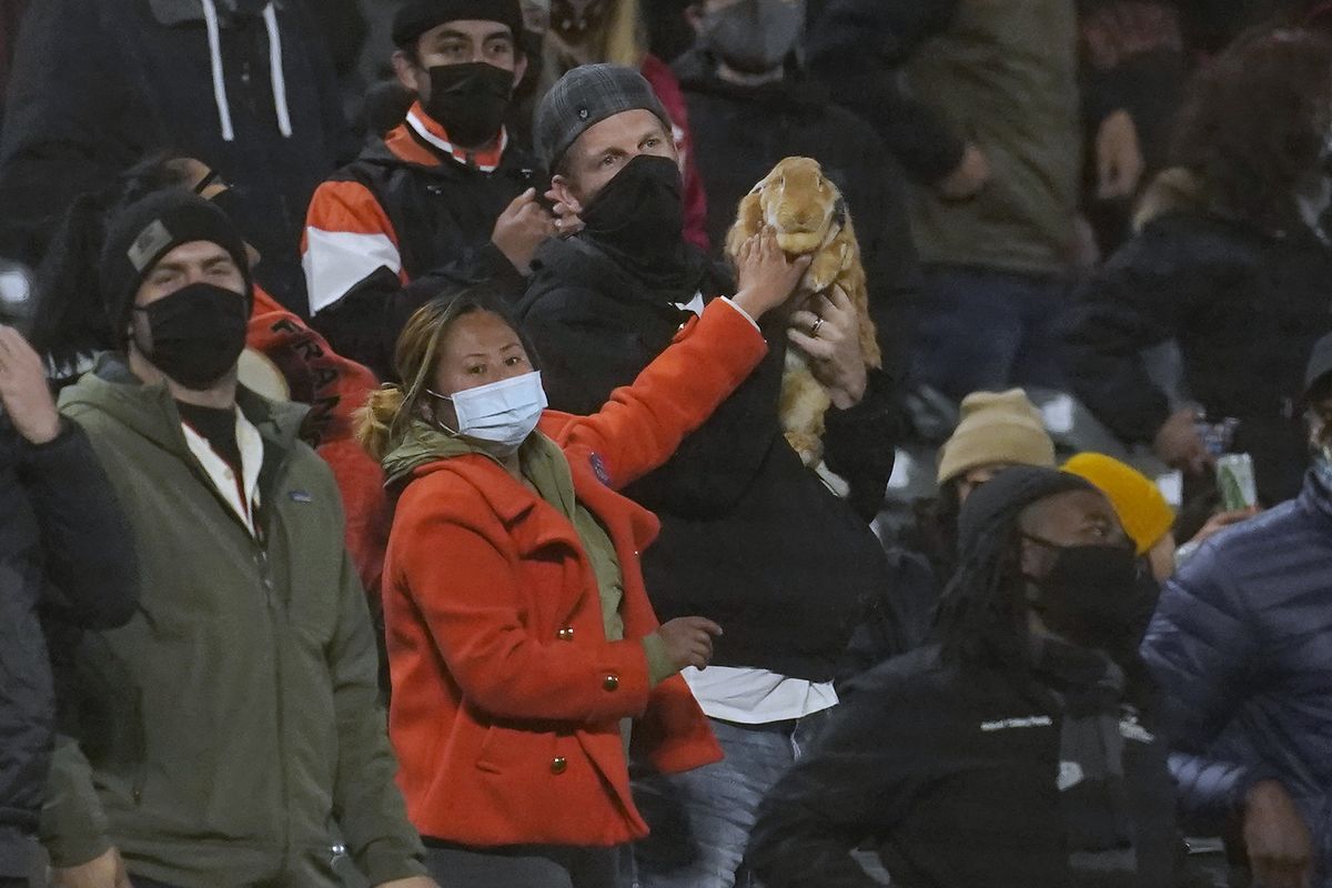 Kei Kato, left, and her fiance, Josh Row, hold a therapy rabbit named Alex during the ninth inning of a baseball game between the San Francisco Giants and the Miami Marlins in San Francisco, Thursday, April 22, 2021.  (Associated Press)