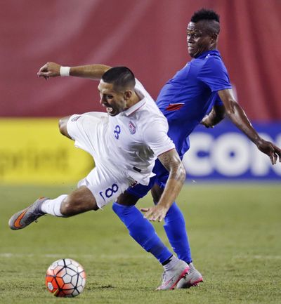 Clint Dempsey, left, is knocked off the ball by Wilde Donald Guerrier. (Associated Press)