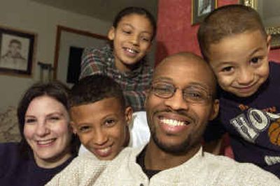 Deon Watson, center, who was hit by a car and is laid up for several months, is surrounded by his wife, Anna, far left, son Deon, 10, second from left, daughter Haile, 8, upper left, and youngest son Anton, 4. Watson is a former UI basketball player who also played overseas. He now works for URM.
(Jesse Tinsley / The Spokesman-Review)