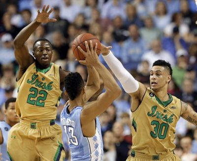 Notre Dame’s Jerian Grant, left, and Zach Auguste smother North Carolina’s J.P. Tokoto during the ACC title game. (Associated Press)