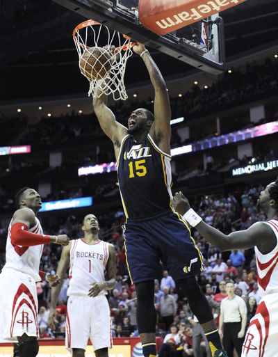 Utah Jazz's Derrick Favors, center, dunks the ball in the final seconds. (Associated Press)